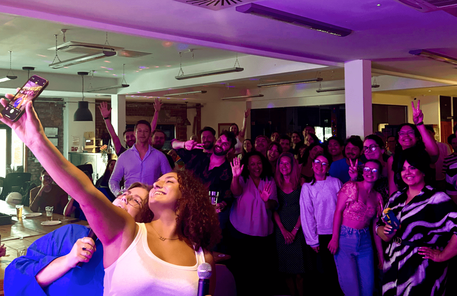 Person raising hands in front of a group.