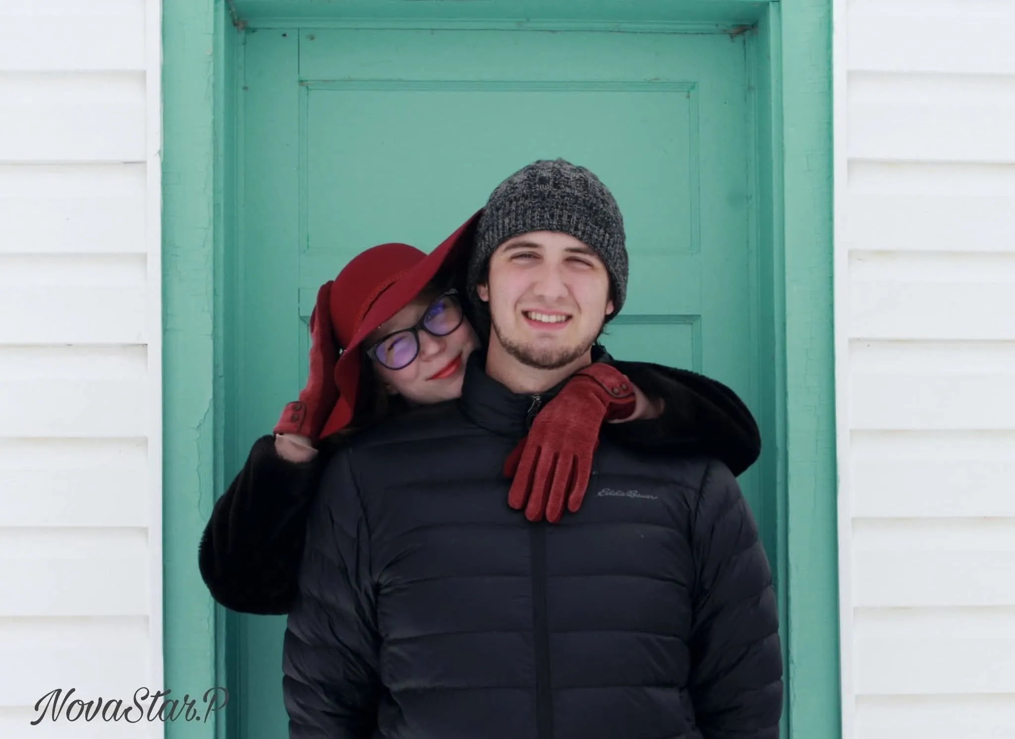 A couple stands outdoors at sunset.
