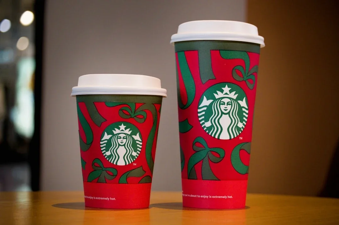 Two starbucks cups with holiday designs.