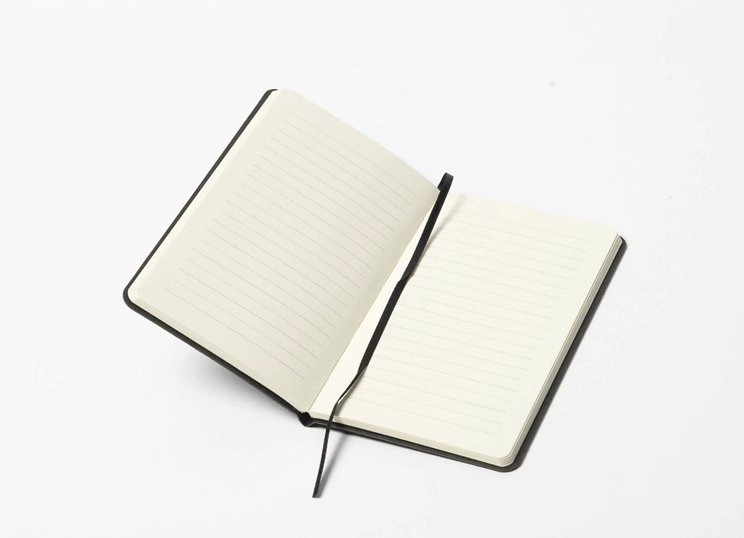 Open hardbound journal showing ruled ivory pages and ribbon bookmark