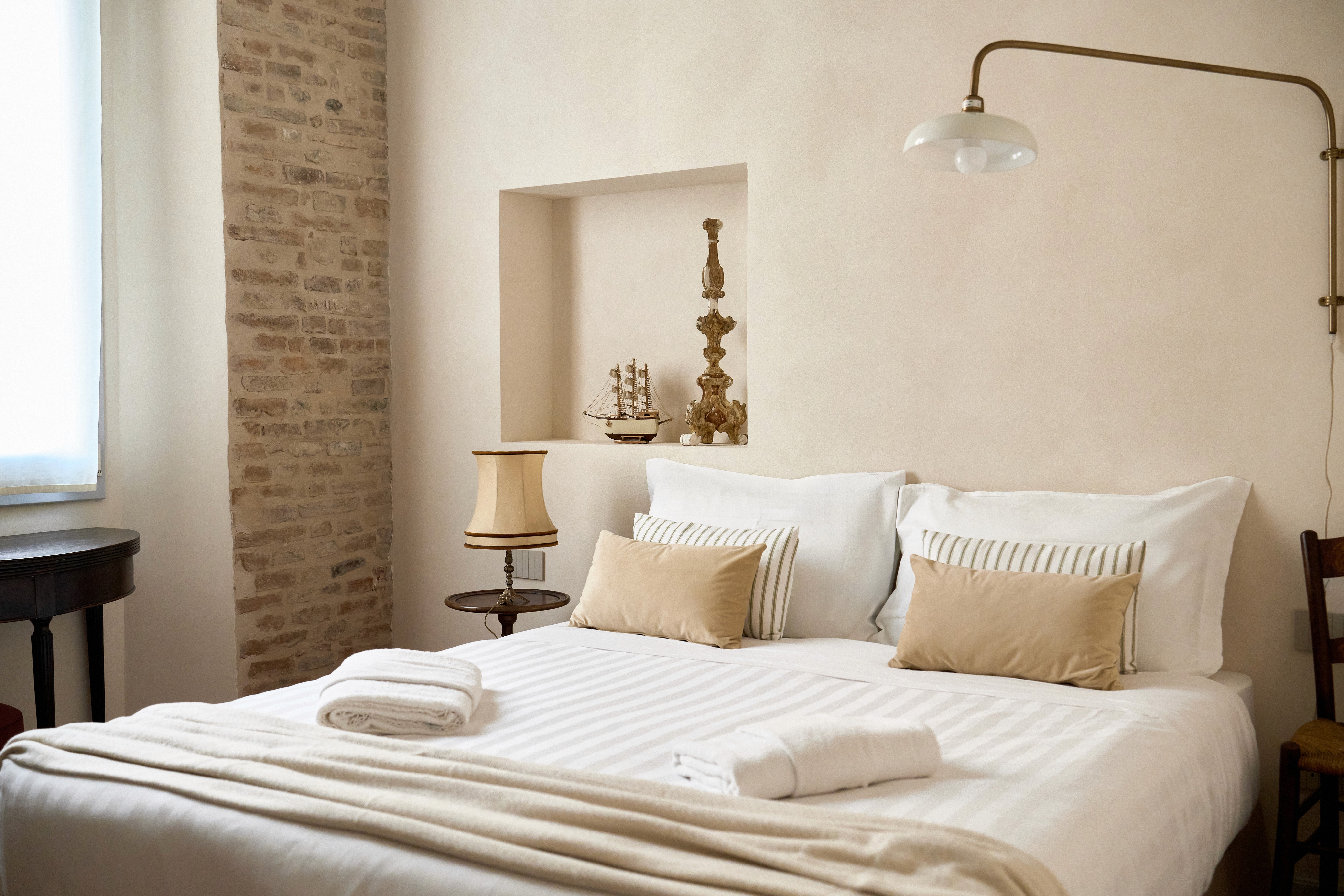 A luxurious indoor pool area with a panoramic view of a city at sunset. Comfortable lounge beds with soft fabrics surround the pool, while warm ambient lighting enhances the sophisticated atmosphere. The space combines modern elegance with a tranquil vibe.