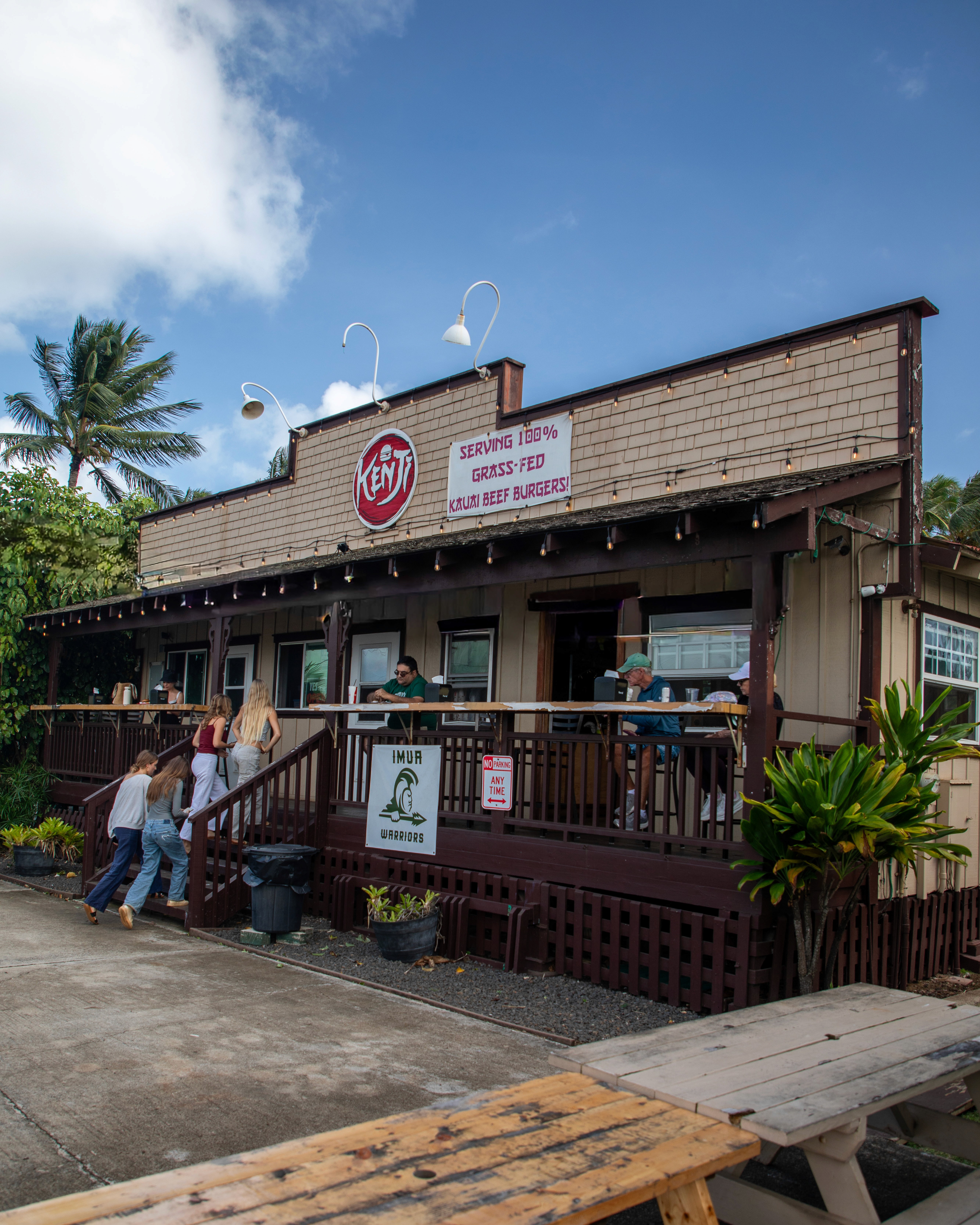 A beautifully plated dish featuring shrimp, colorful vegetables, and garnishes, set in a modern restaurant.