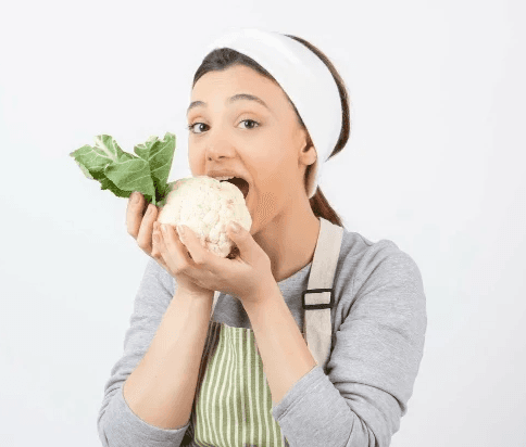 Jeune fille croquant dans un radis frais avec plaisir, découvrant les bienfaits des aliments bruts pour sa santé intestinale.