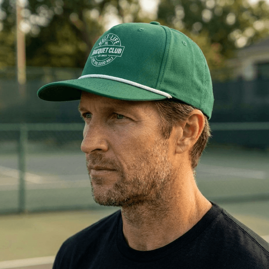 Man wearing a green cap with a logo on a tennis court