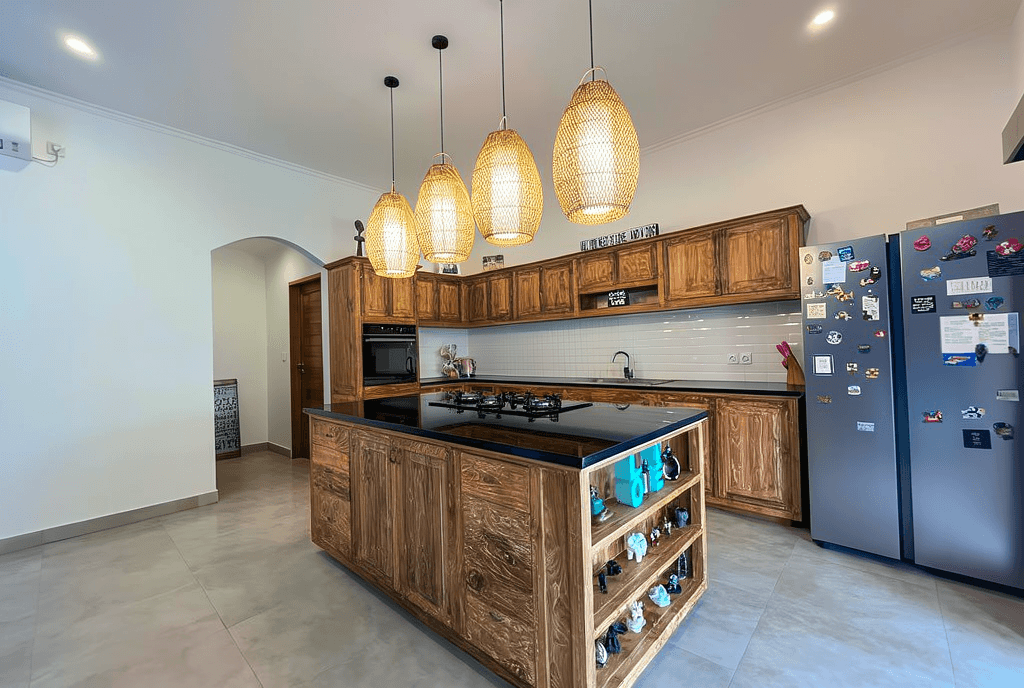 Stylish wooden kitchen island with designer lighting. Leading real estate agent for modern Canggu property listings.