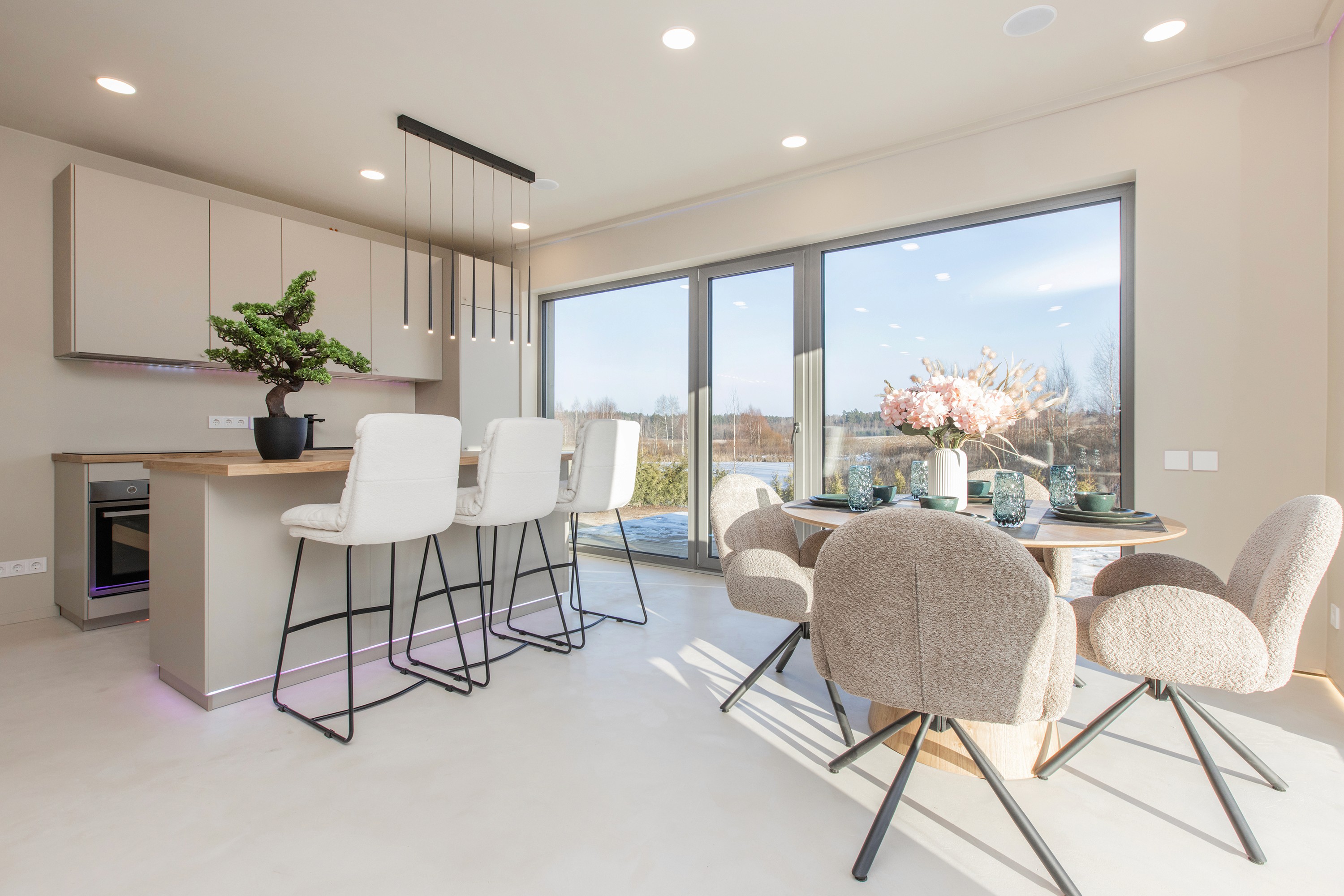 Dining area with natural light and modern furniture in an energy-efficient home built by Grande Build near Riga.