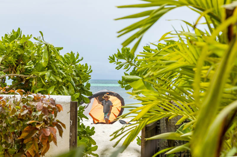 kiter blowing up his kite on the private kite beach of his beachfront apartment in Kiwengwa Zanzibar