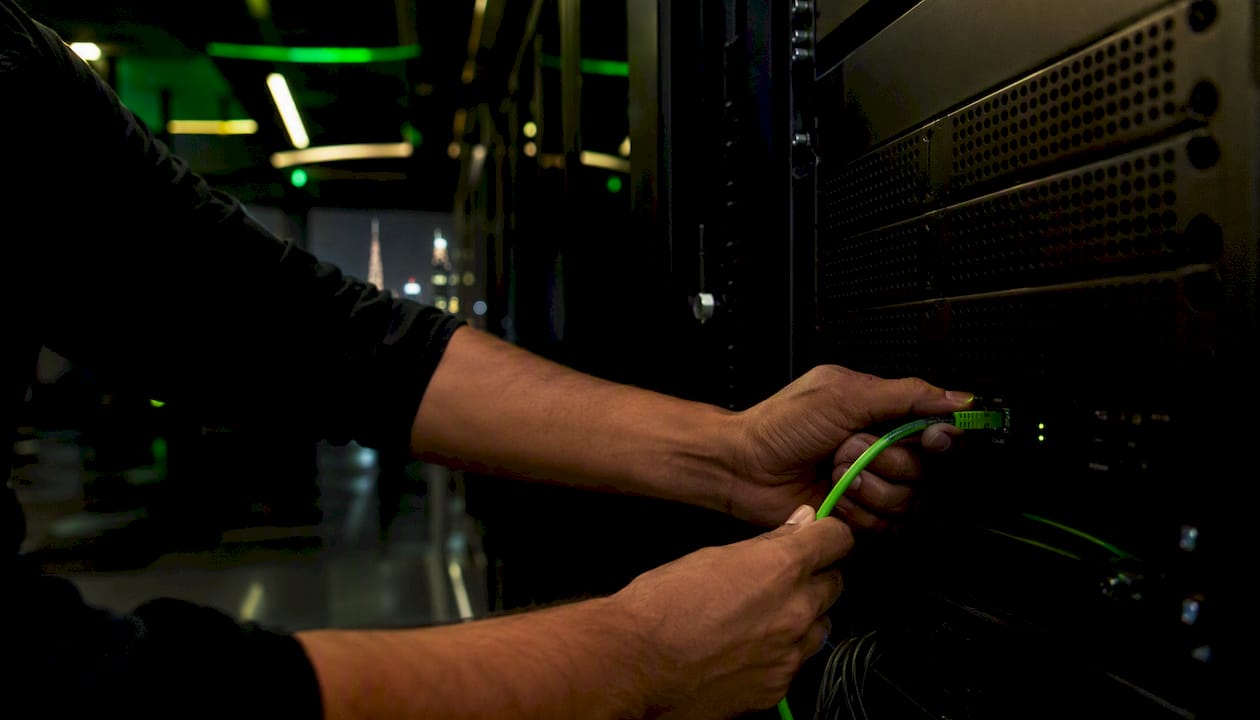 Hands connecting network cable in tech innovation workspace