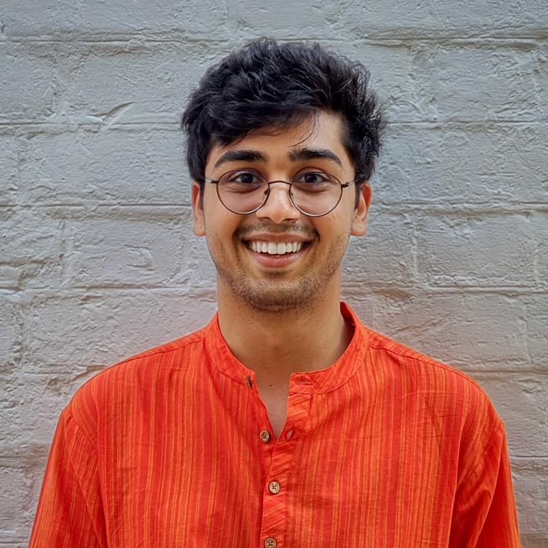 A portrait of Maitreya Pathak, a student from the class of 2027, featuring a friendly smile and a casual outfit, set against a vibrant background.