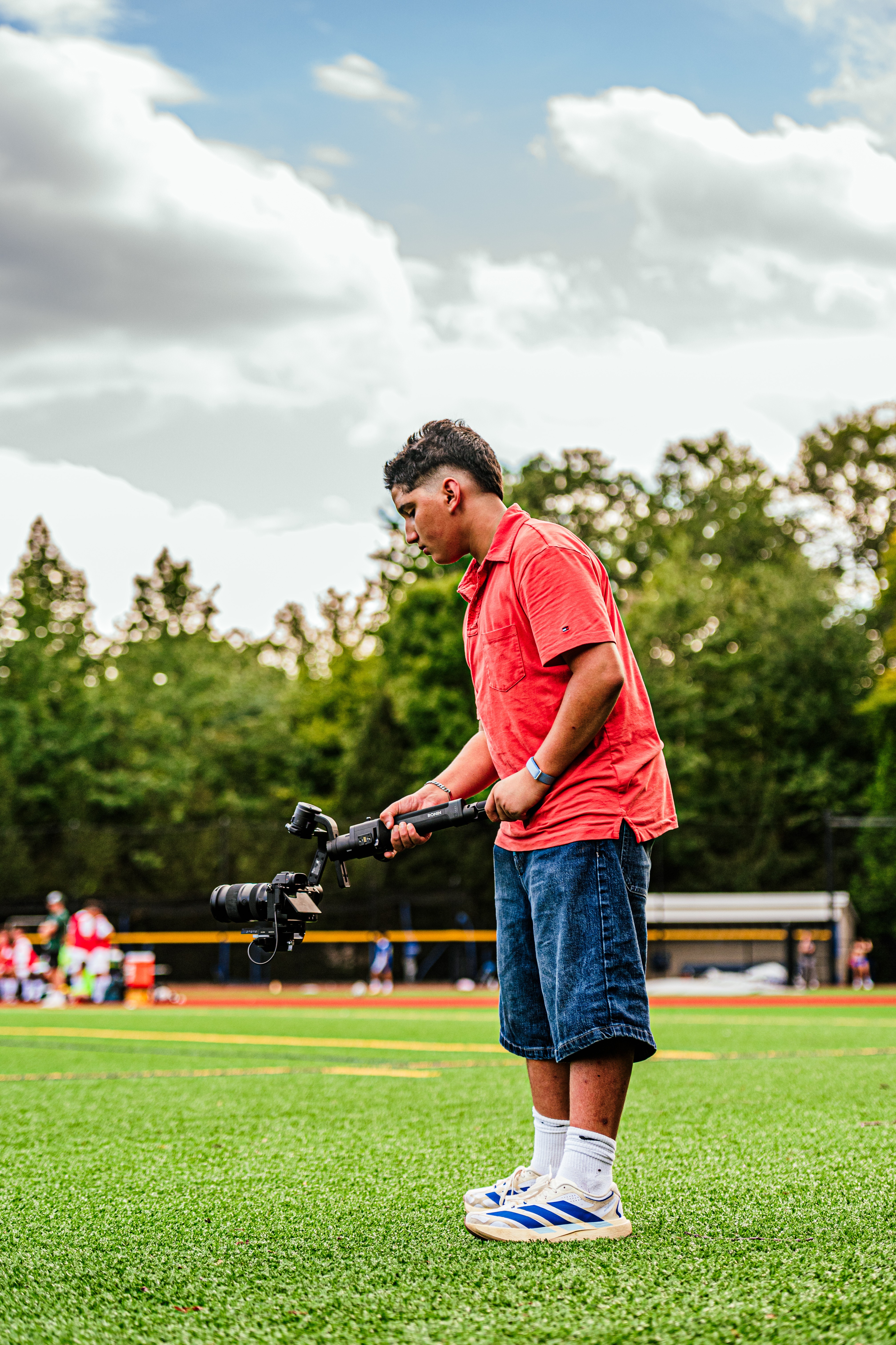 Nico filming on a sports field with a camera stabilizer