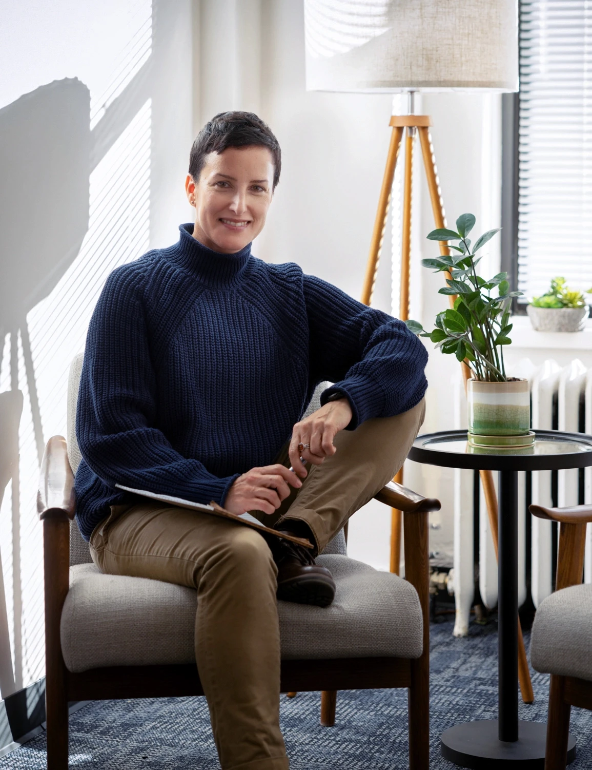 photo of an expansive therapy therapist sitting in a modern inviting office space with couches and plants overlooking a big window framing the new york city skyline representing the affirming identity supporting bisexual affirming therapy found at expansive therapy.