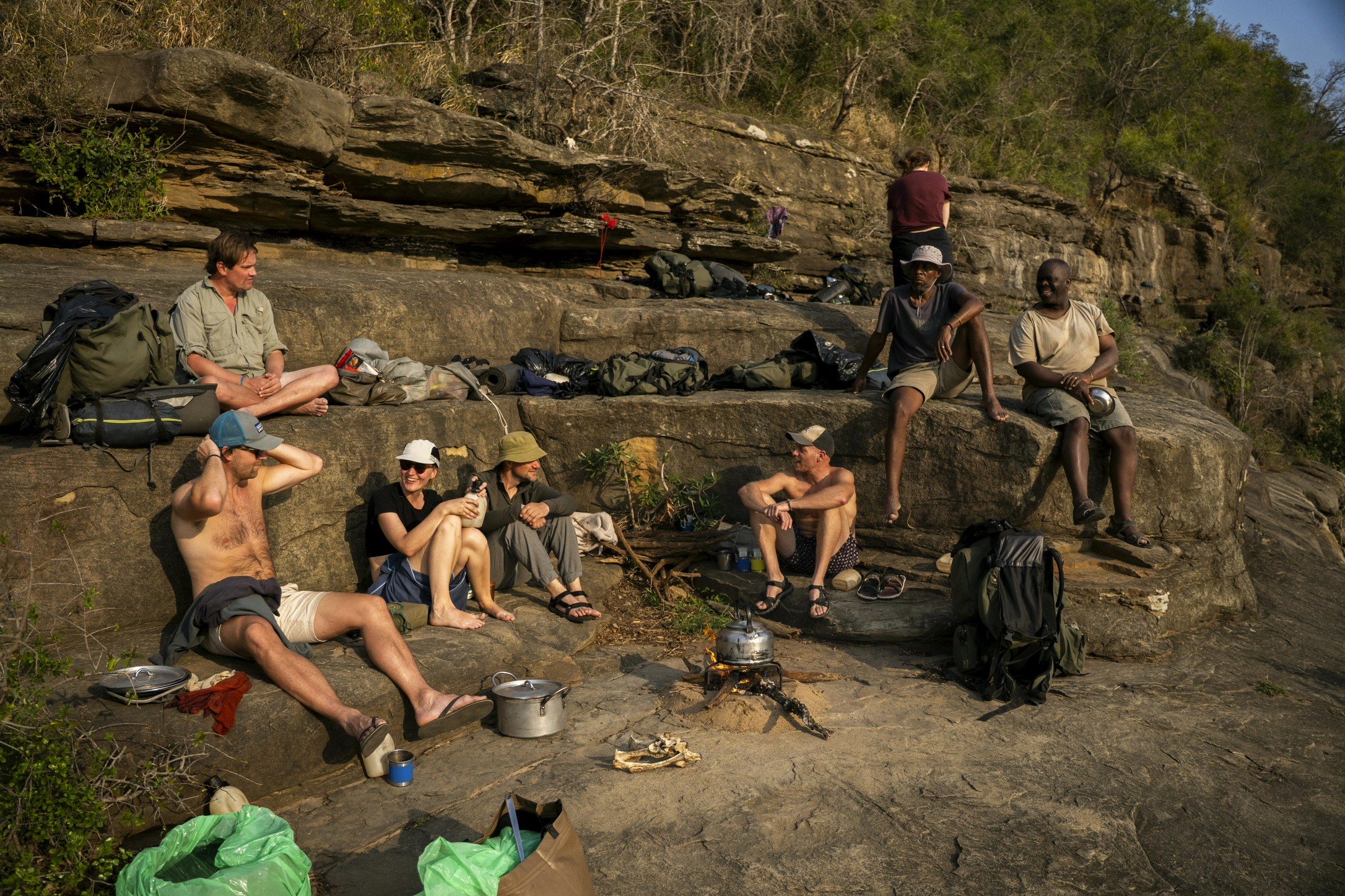 A group resting at rocks next to a river