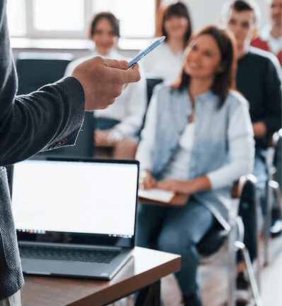 Group of people in a meeting, collaborating in a modern office with laptops.