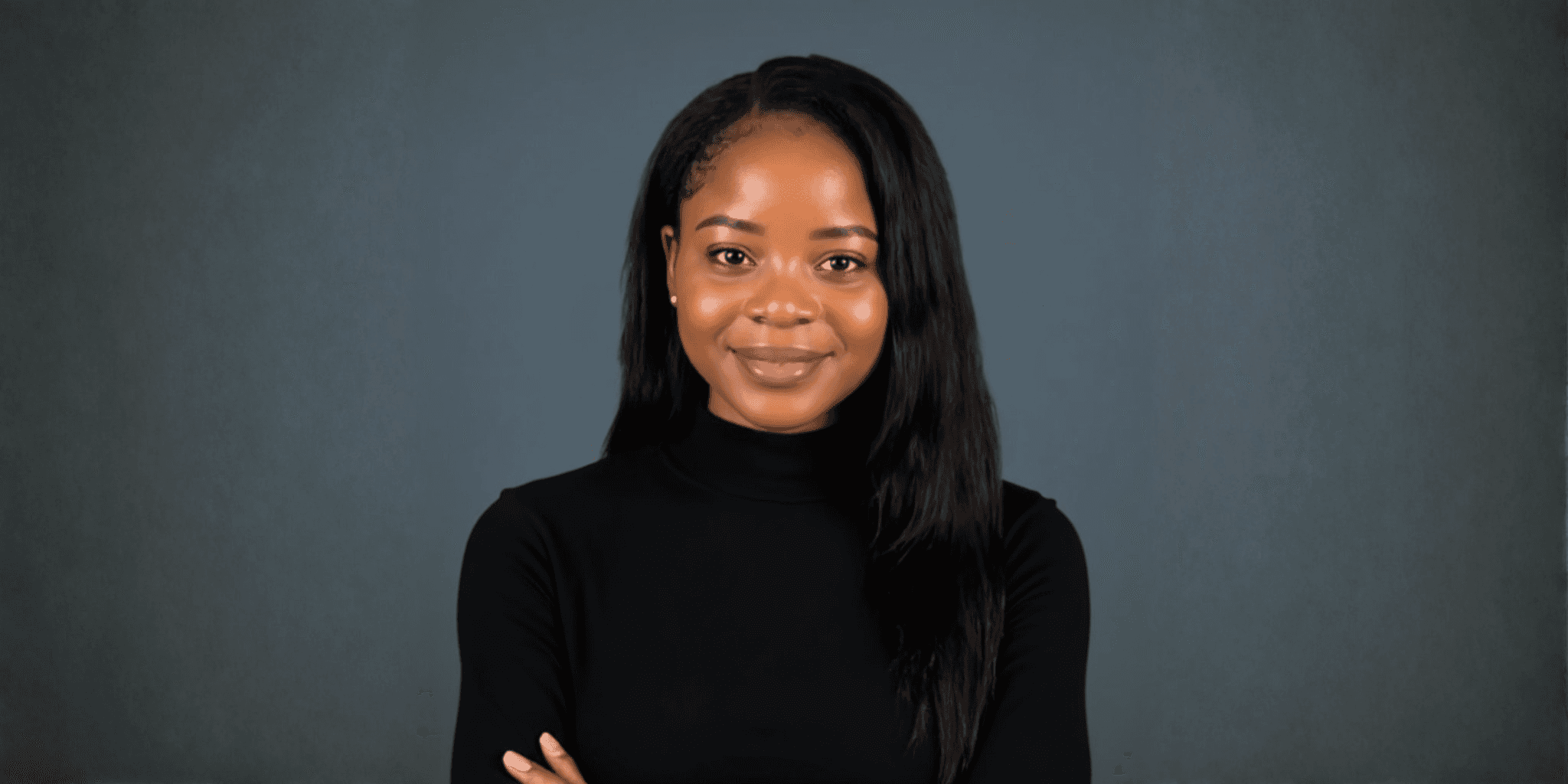 Portrait of a smiling woman in a black turtleneck against a gray background.