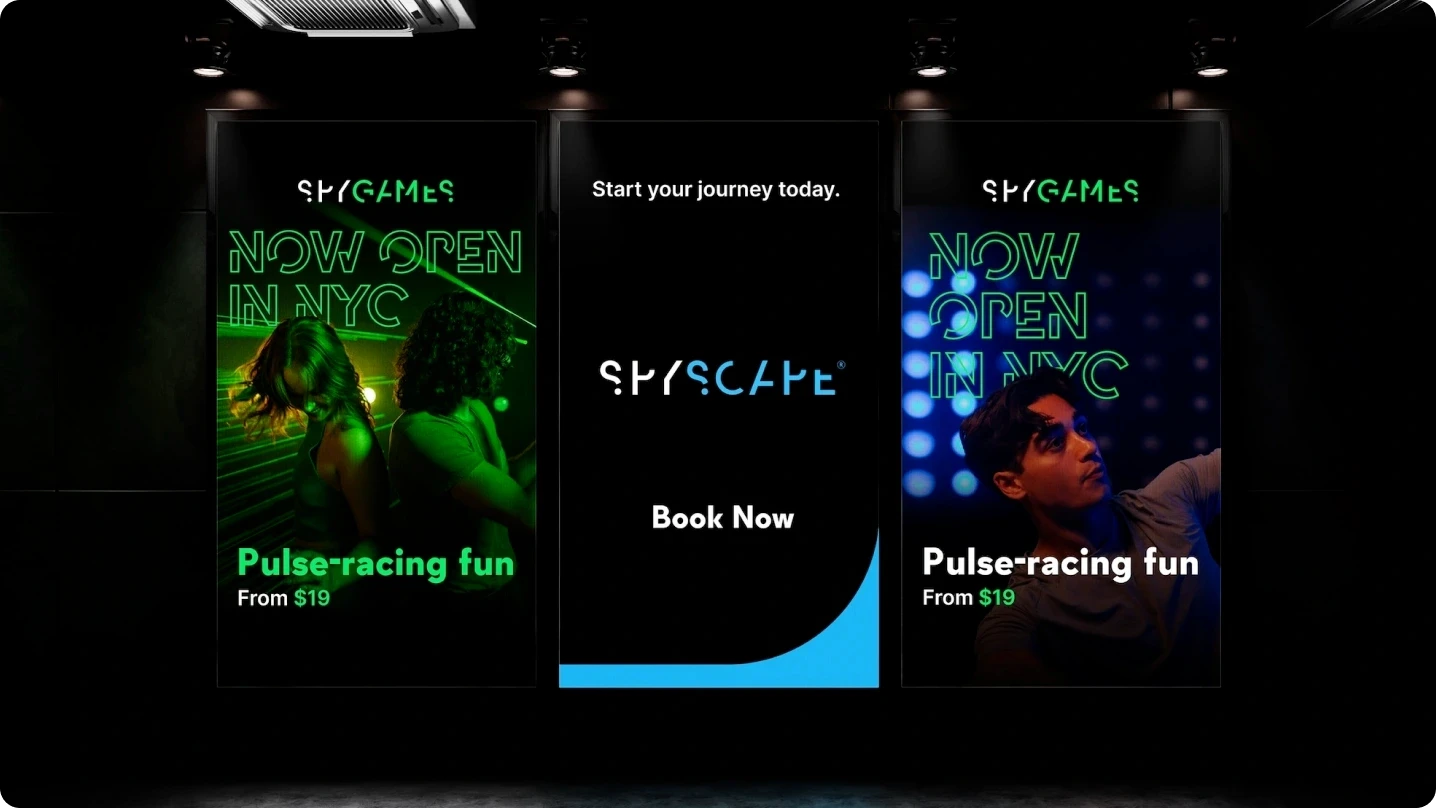 Three SPYSCAPE posters in a dark indoor space promoting NYC opening, featuring neon green and blue visuals with people enjoying interactive experiences.