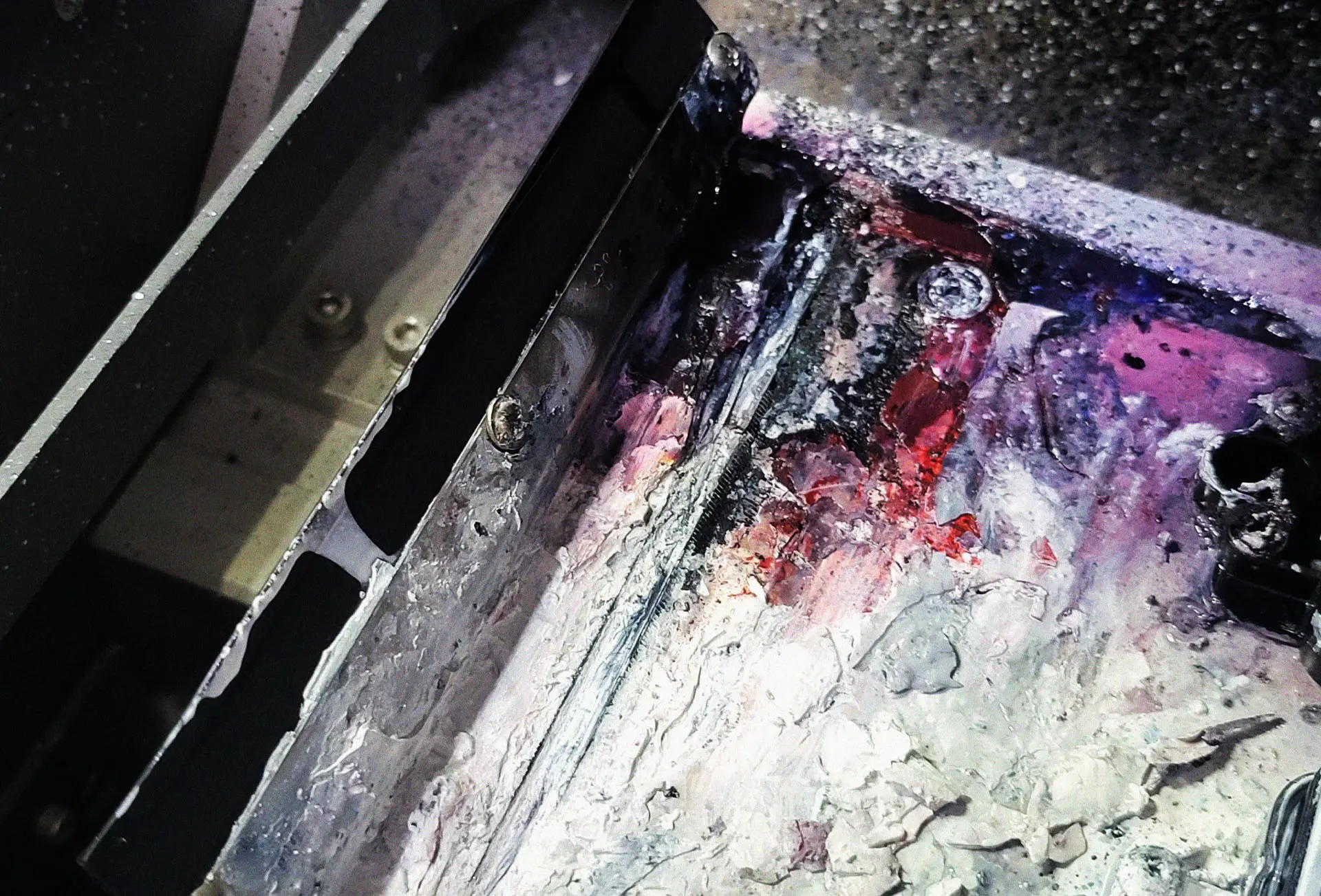 Close-up view showing dry residual ink and a remaining exposed blade on an old DTF printer maintenance system, a condition leading to nozzle damage.