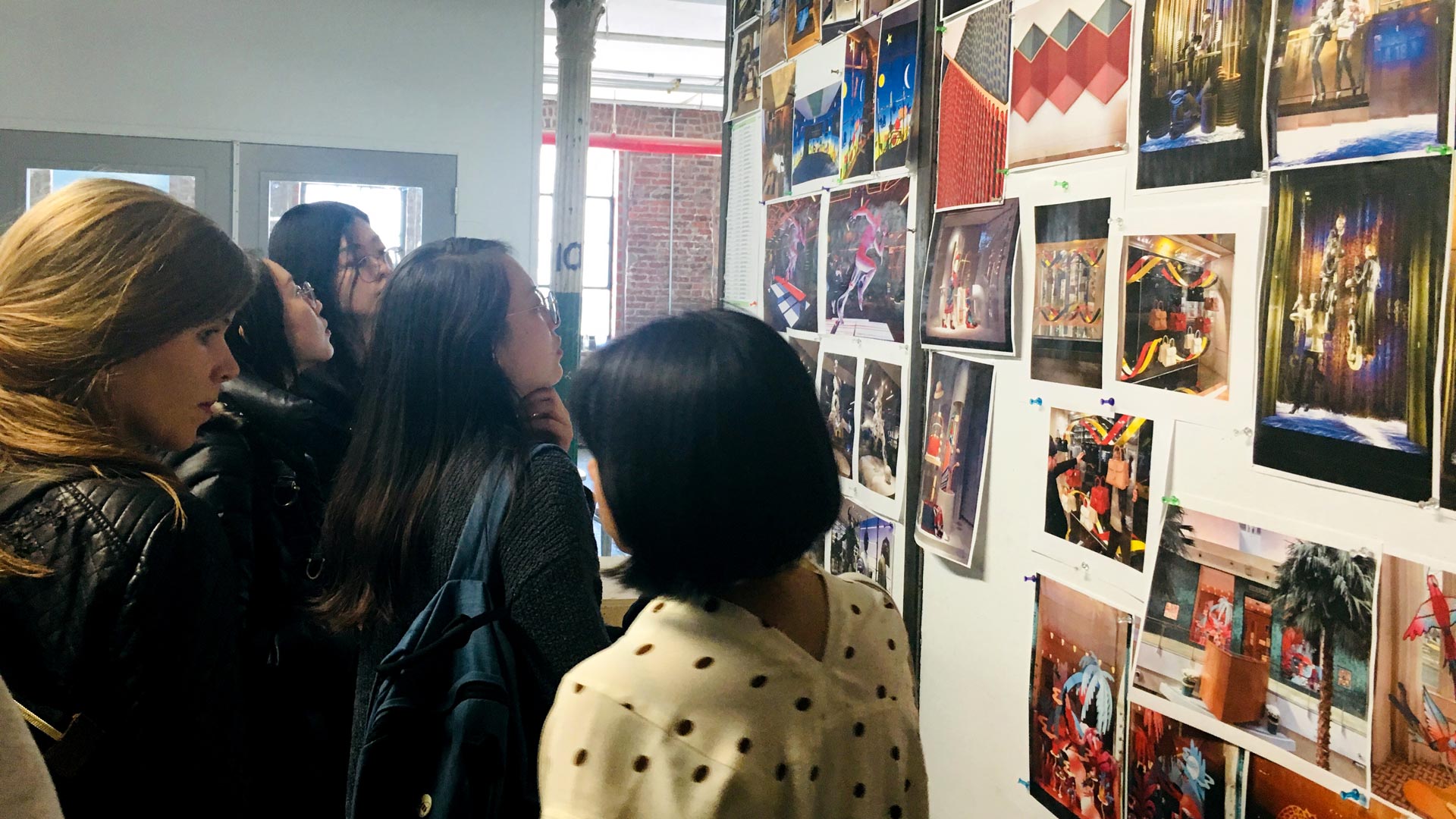 People looking at posters on hang on a wall