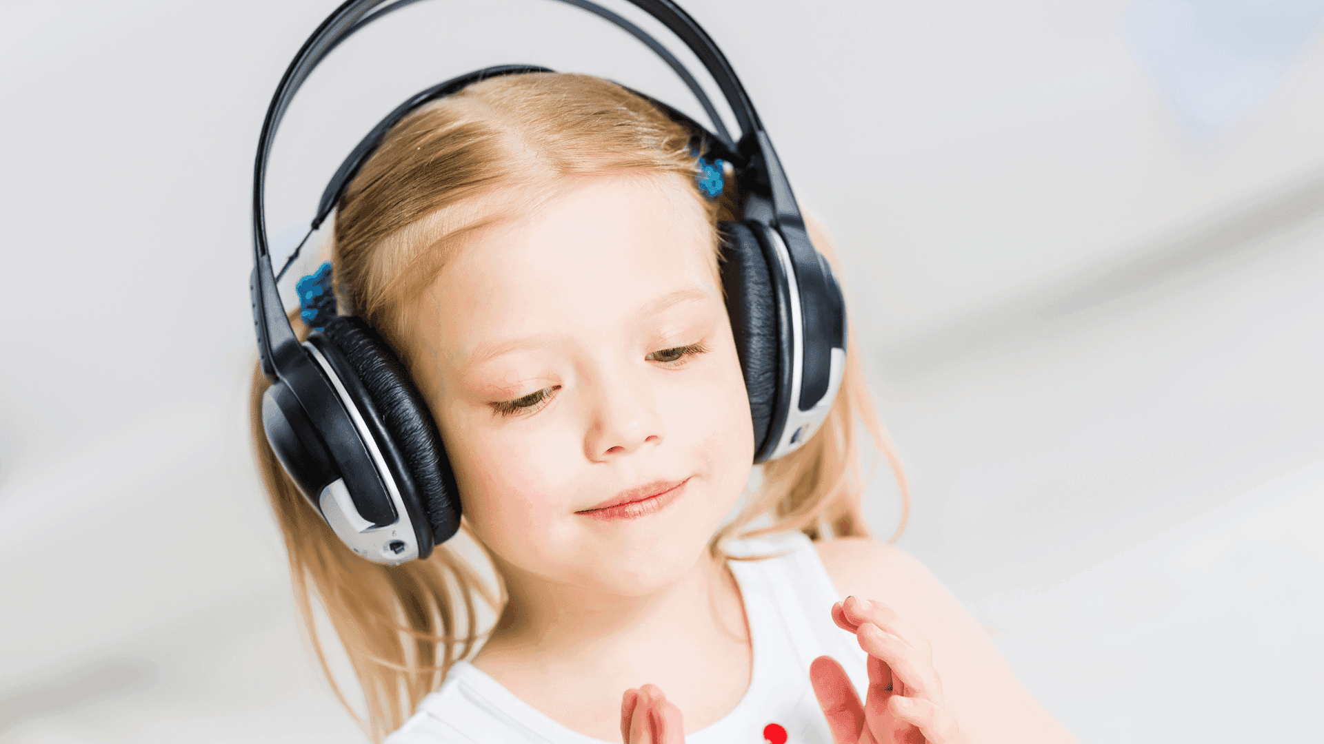 A young girl smiling and wearing headphones while listening to HushAway®’s Sound Sanctuary.