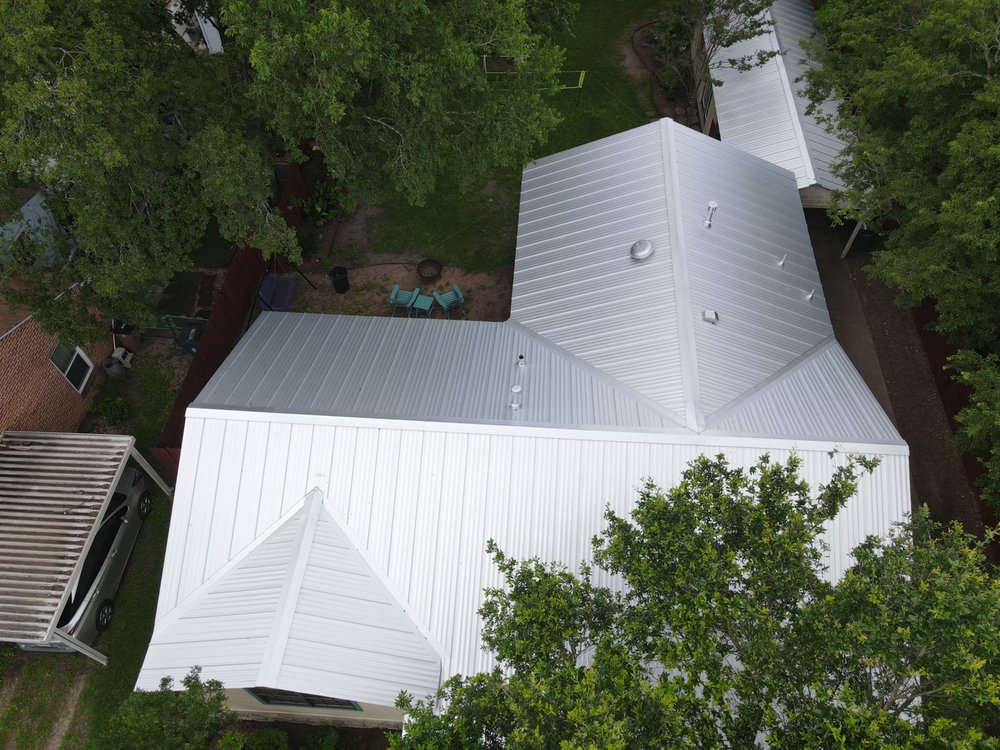 Beautiful Galvalume standing seam cross-hipped roof with perforated zee bar for optimal ventilation.