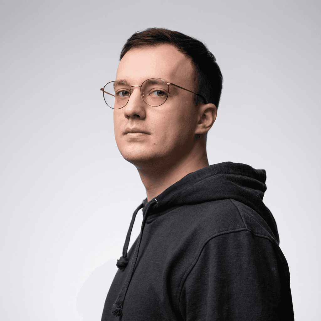 A thoughtful young person with dark hair gazes to the side, captured in soft black and white lighting.