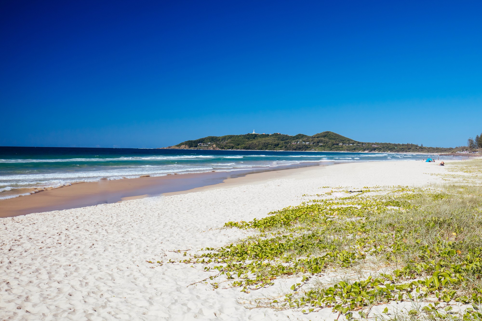 main beach byron bay with lighthouse in the background