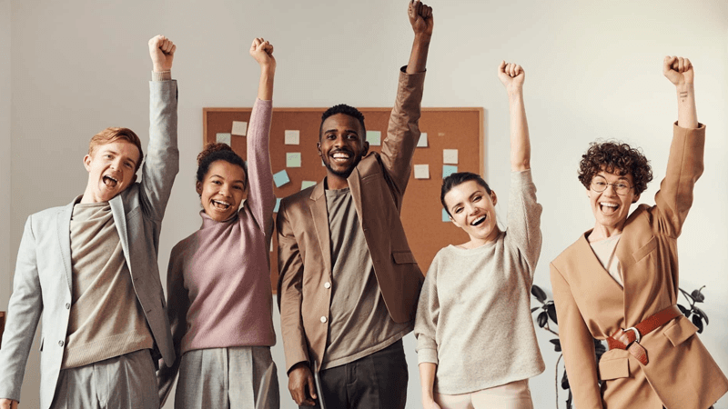 Motivated team celebrating success in the workplace — People Yield employee engagement