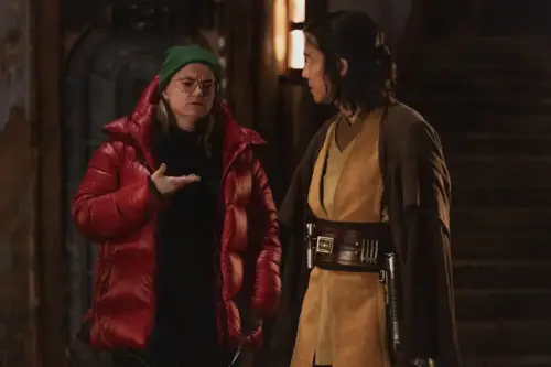 Leslye Headland in a red jacket giving direction to Lee Jung-jae in costume