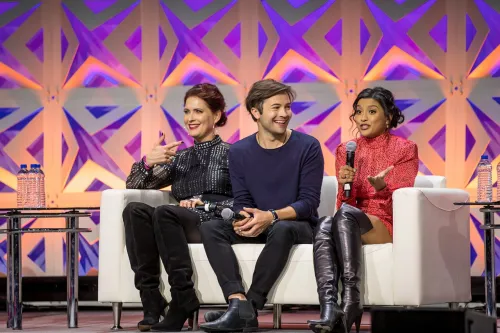 Vanessa Marshall, Tayler Gray, and Tiya Sircar on a white couch on a stage