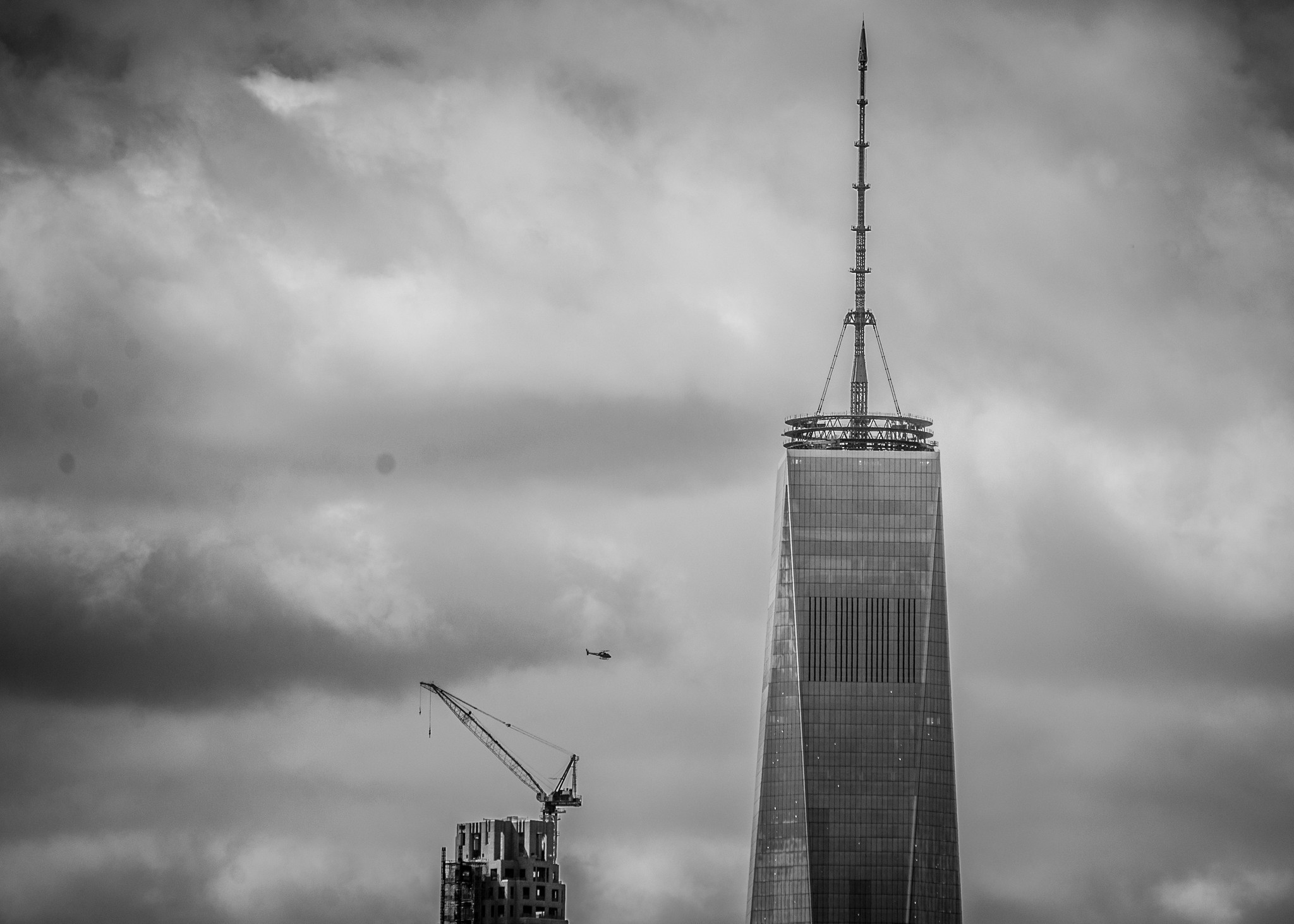 Freedom Tower in downtown Manhattan with a helicopter circling.