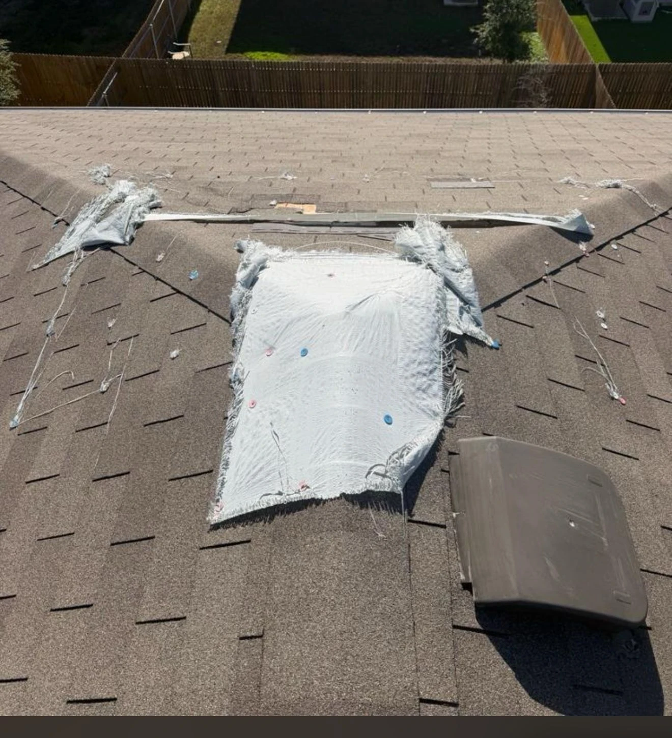 Before repair: wind-damaged shingles restored in Austin, Texas.