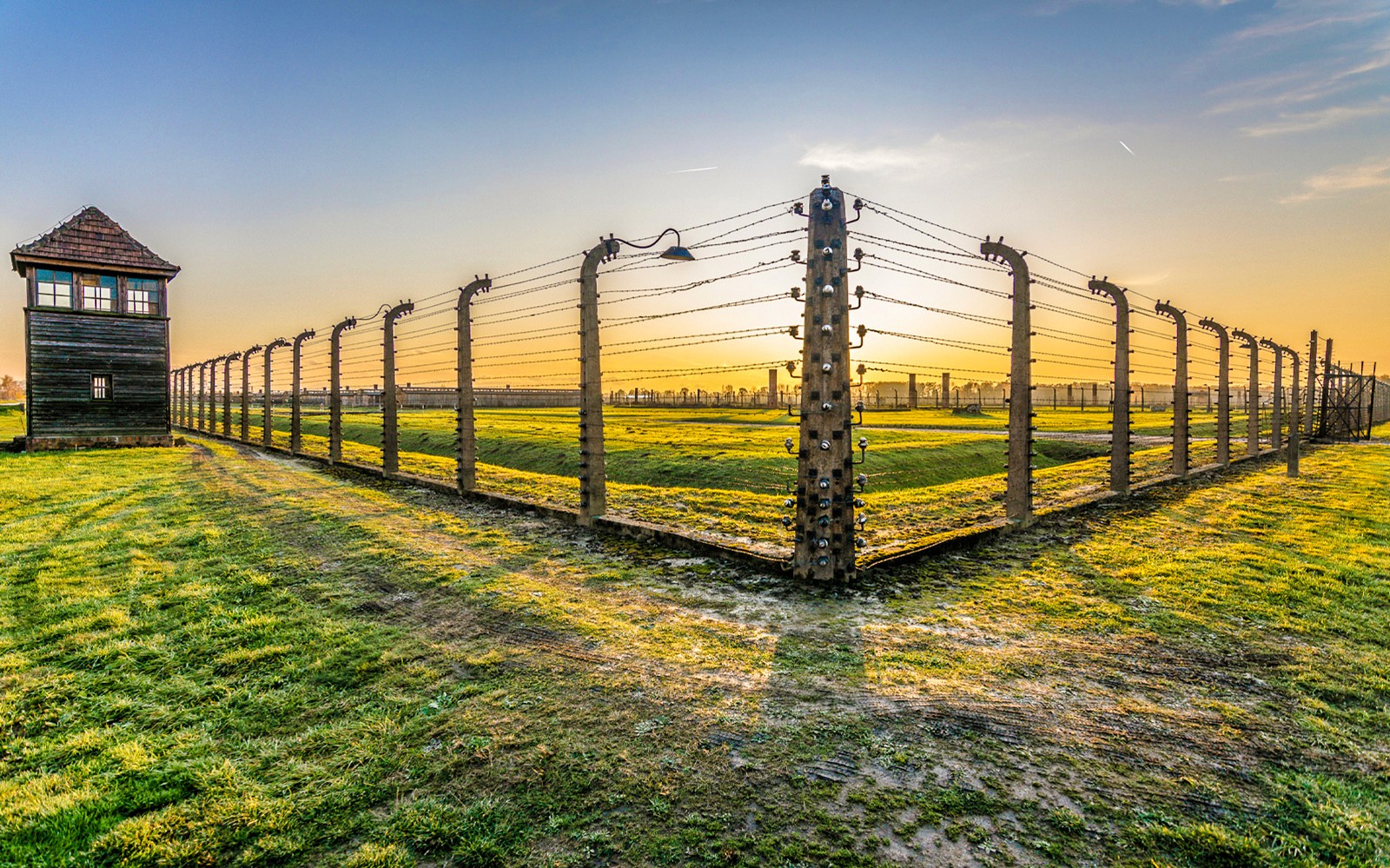 Girðing og varðturn í Auschwitz-Birkenau við sólsetur á leiðsögn frá Kraká.