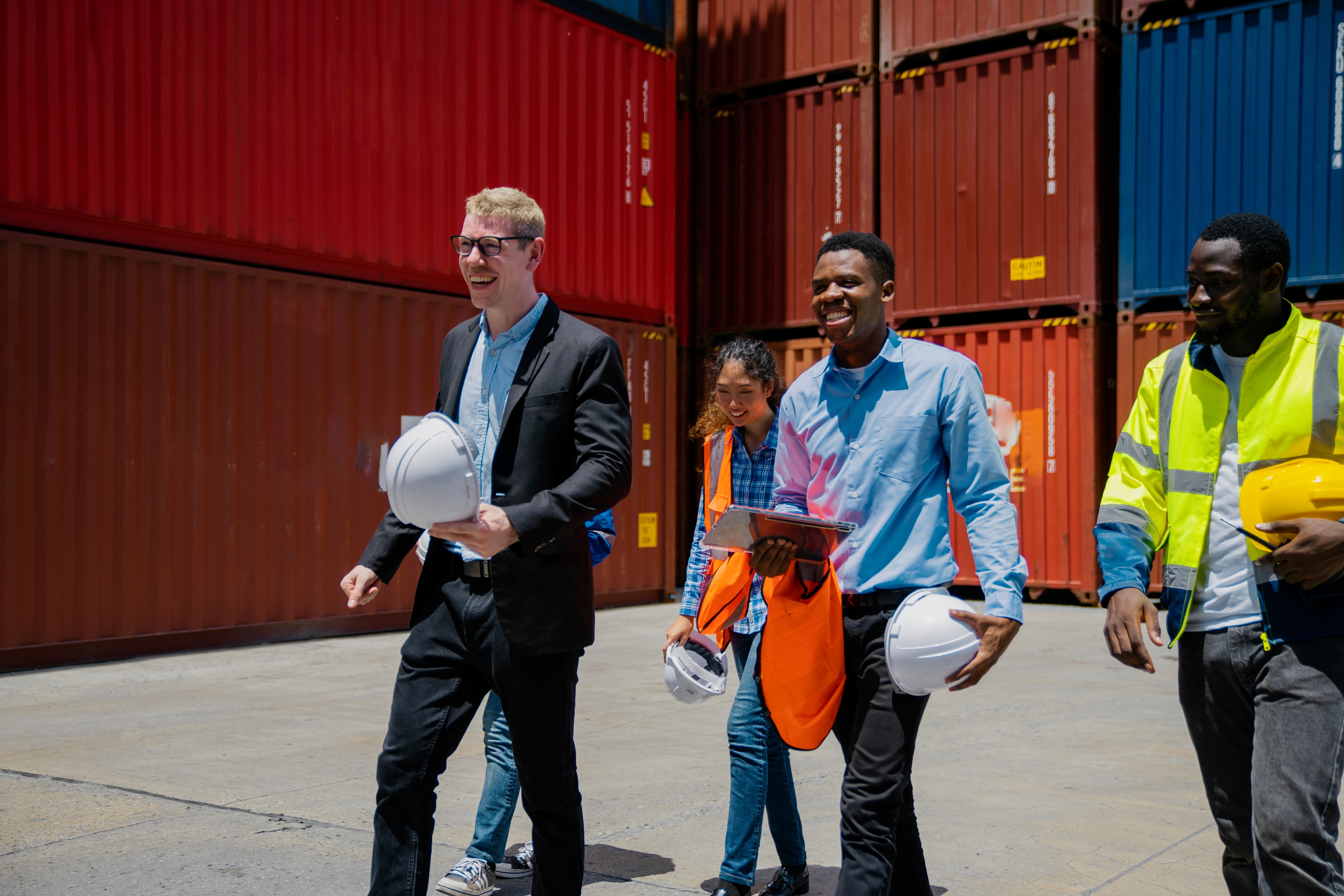 Mitarbeiter eine Unternehmens aus der Logistik gehen durch einen Container-Hafen