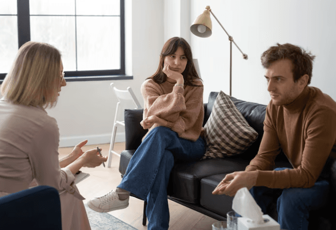 A therapist talking to a man and a woman during couples counselin in Dallas, TX..