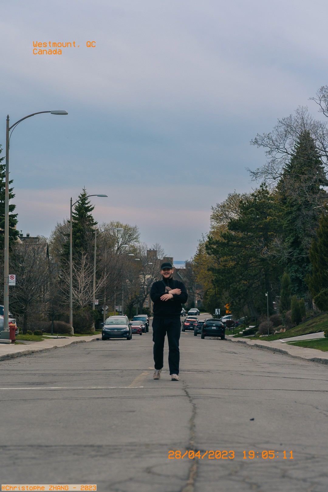 Promenade solitaire d'un homme vêtu de noir dans un quartier tranquille de Westmount.