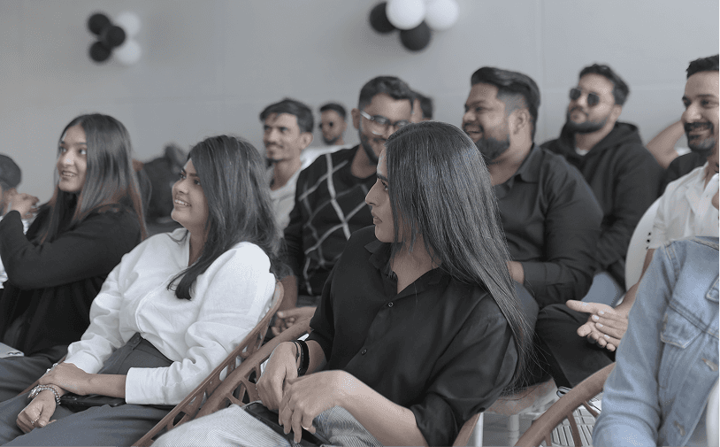Two men discuss a project while standing at a laptop in an office.