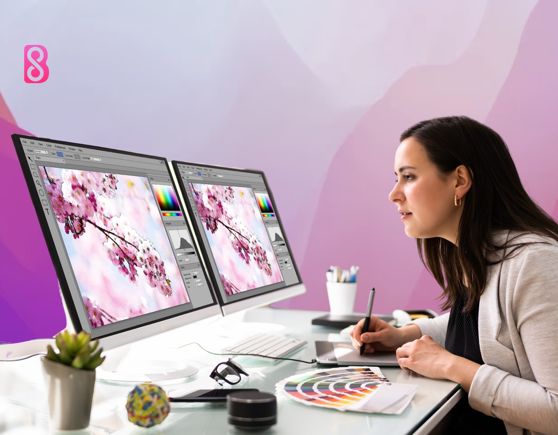 A female who is a graphic designer is sitting on her desk and working on a design