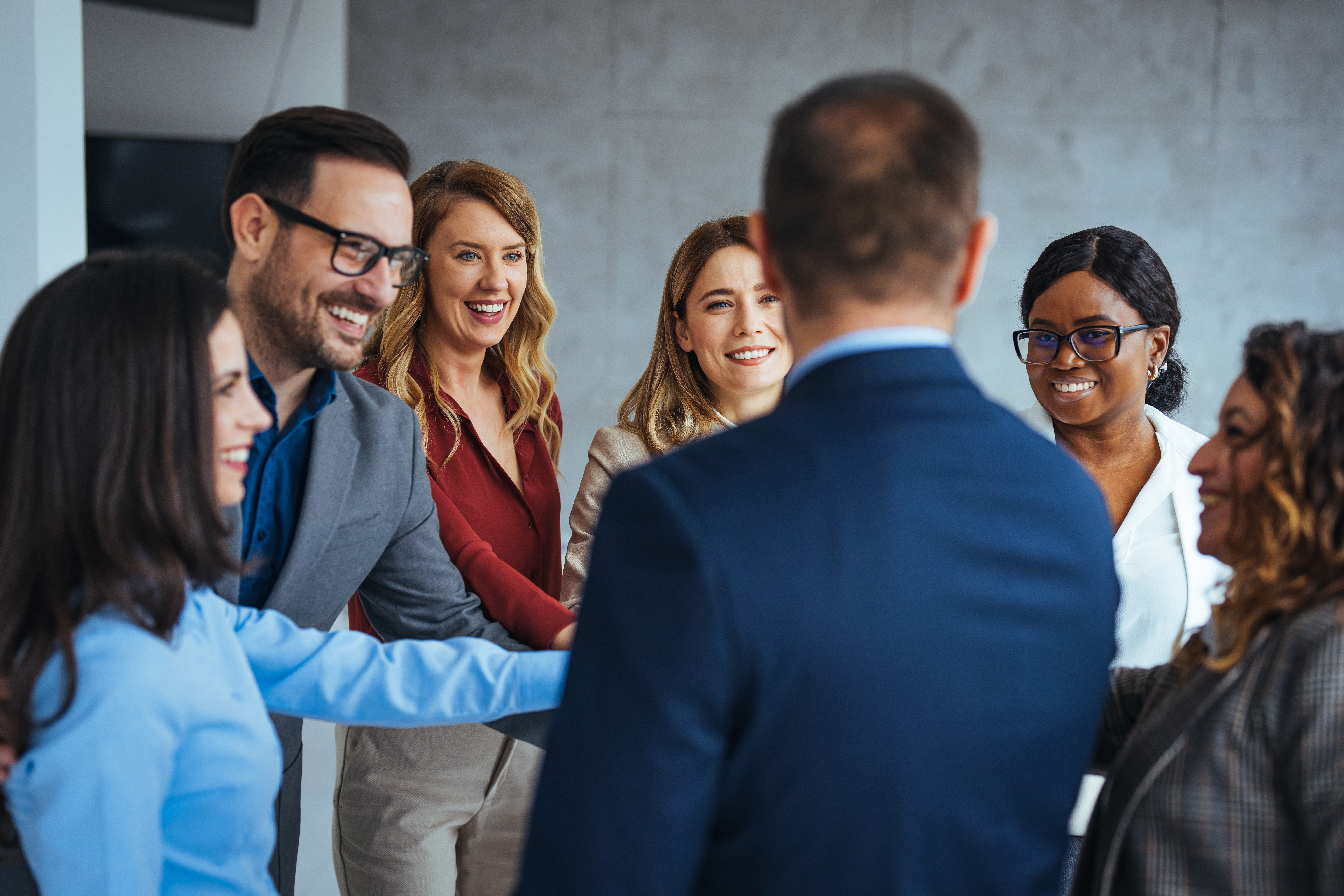 A group of business professionals smiling and engaging in a team-building exercise.