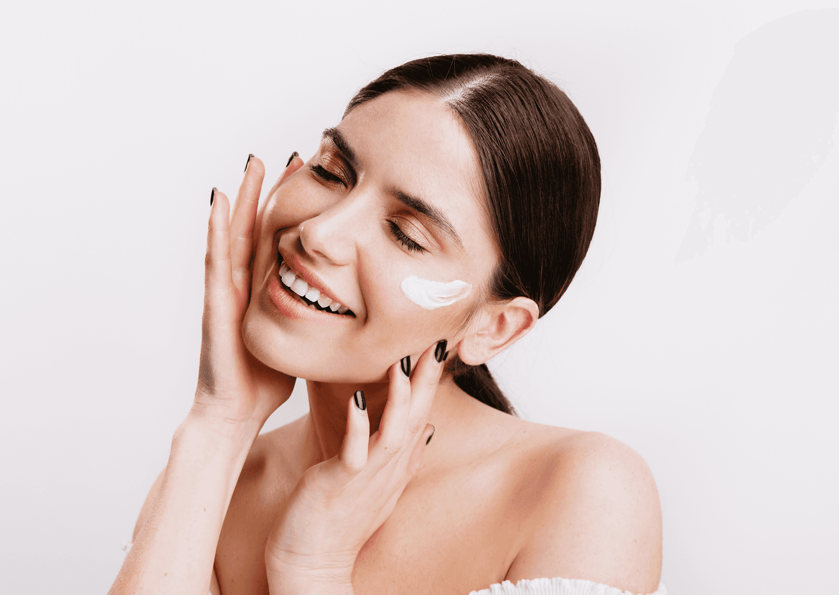 Smiling woman with cream on her cheek.