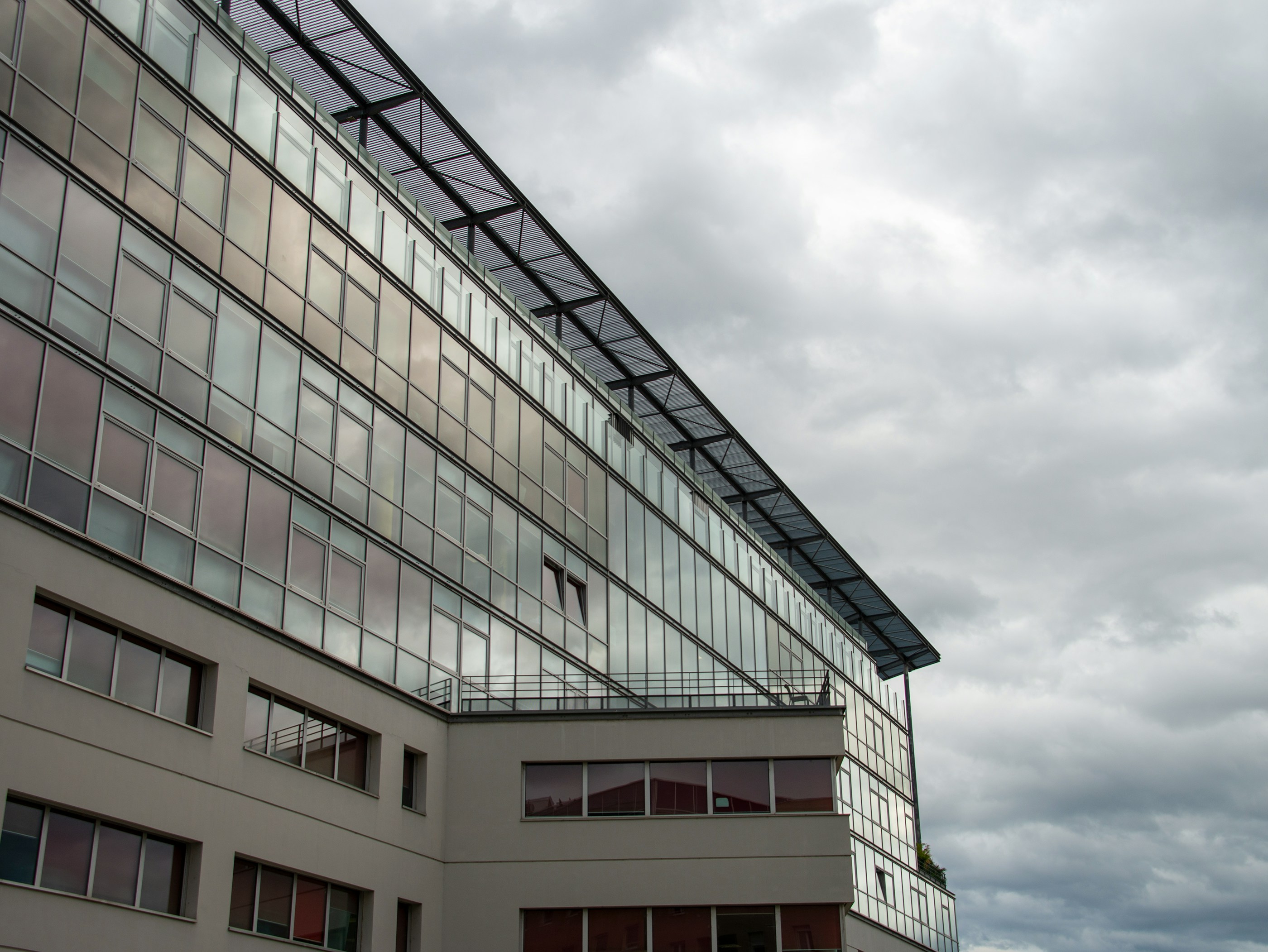 a tall building with lots of windows under a cloudy sky