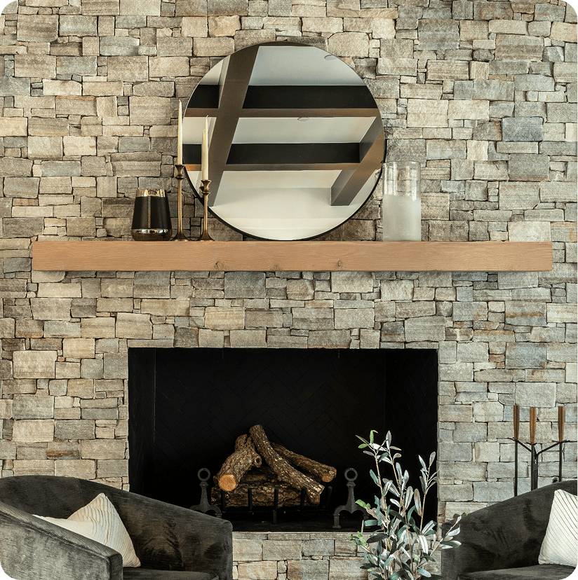 Modern sitting room with natural stone fireplace wall, round mirror, wooden mantel shelf, and contemporary seating