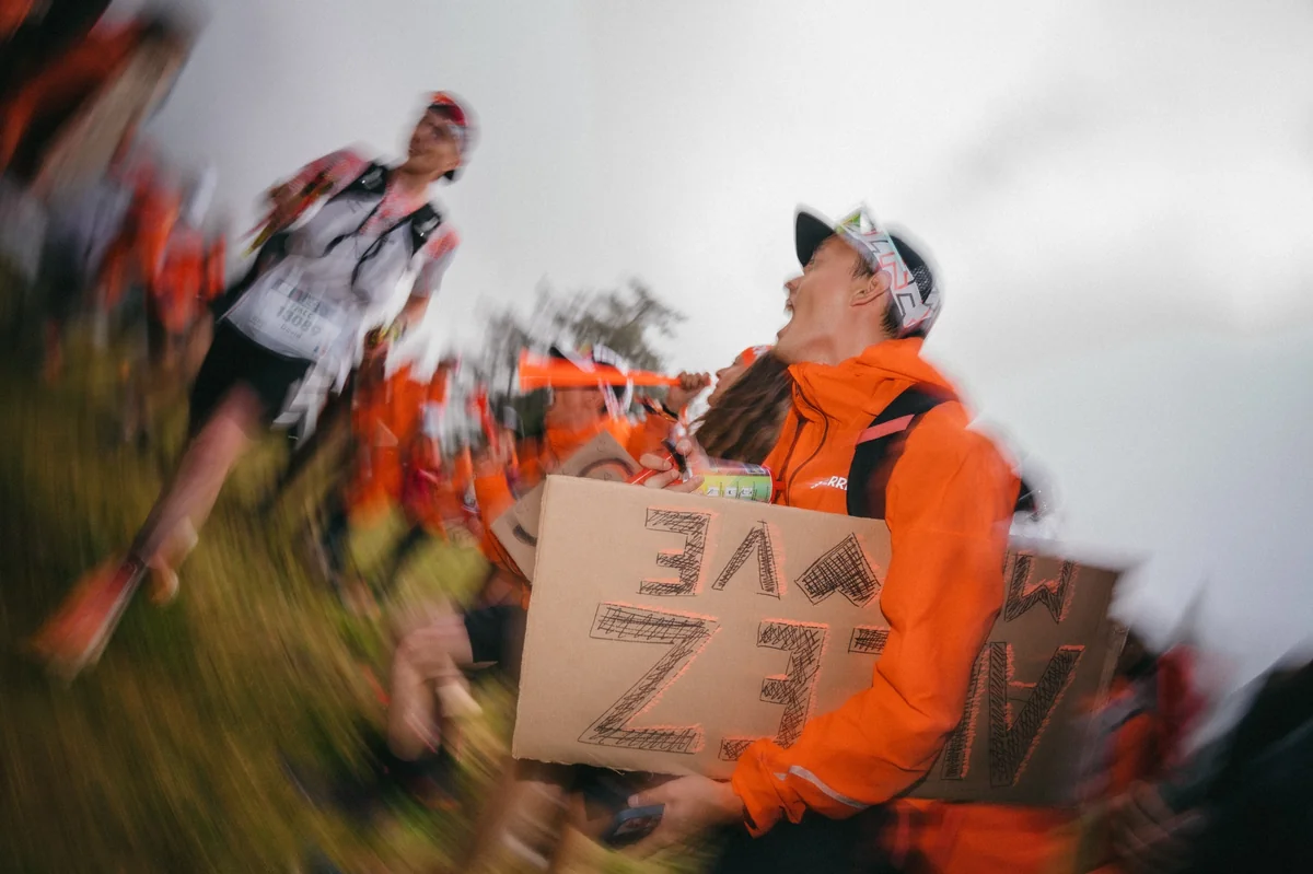 Hero Supporters Adidas Terrex encourageant les coureurs avec pancartes et accessoires sur le parcours UTMB.