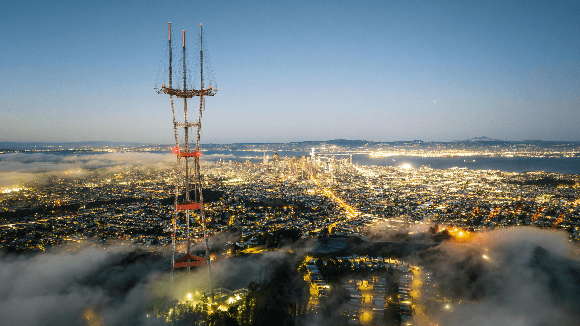 Urban energy infrastructure and transmission tower overlooking a major city, symbolising the link between domestic power systems and national sovereignty