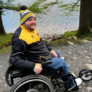 Our customer in his SD Motion Drive wheelchair with a freewheel front wheel, by a lake