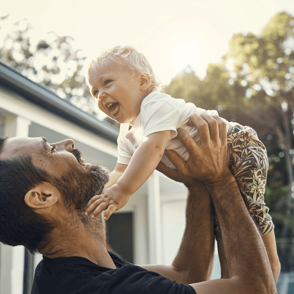image of father lifting up baby