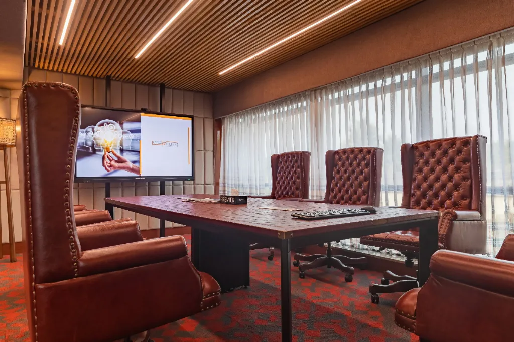Large conference room with high-end leather chairs and a large screen.
