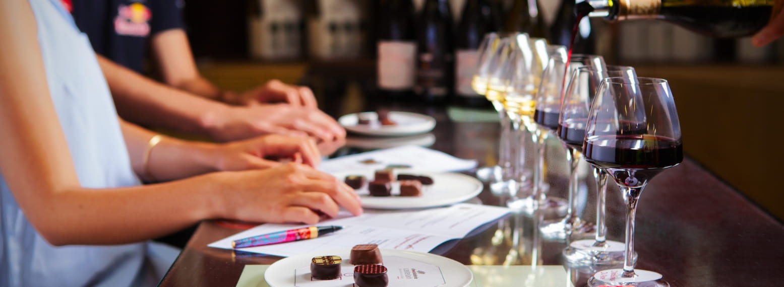 Dégustation de vin et chocolat, personnes appréciant des verres de vin et des chocolats sur une table de dégustation