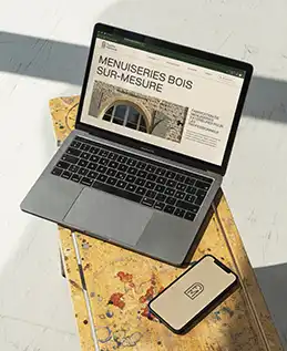 Ordinateur posé sur une planche en bois tâchée de peinture