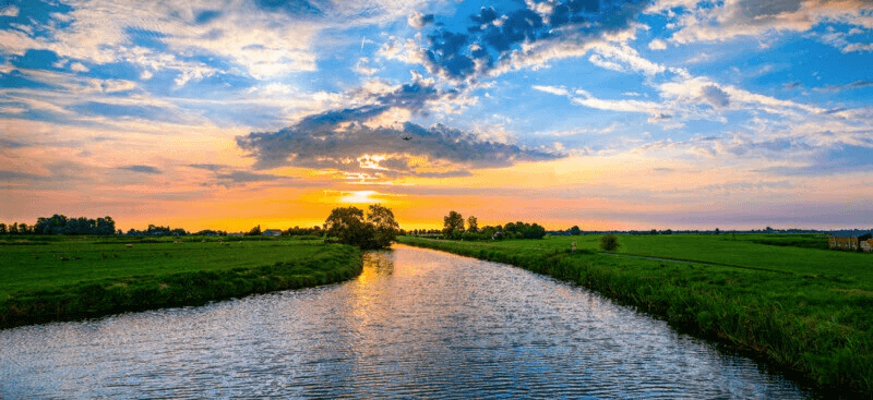 A scenic view of a beautiful river with mountains and trees.
