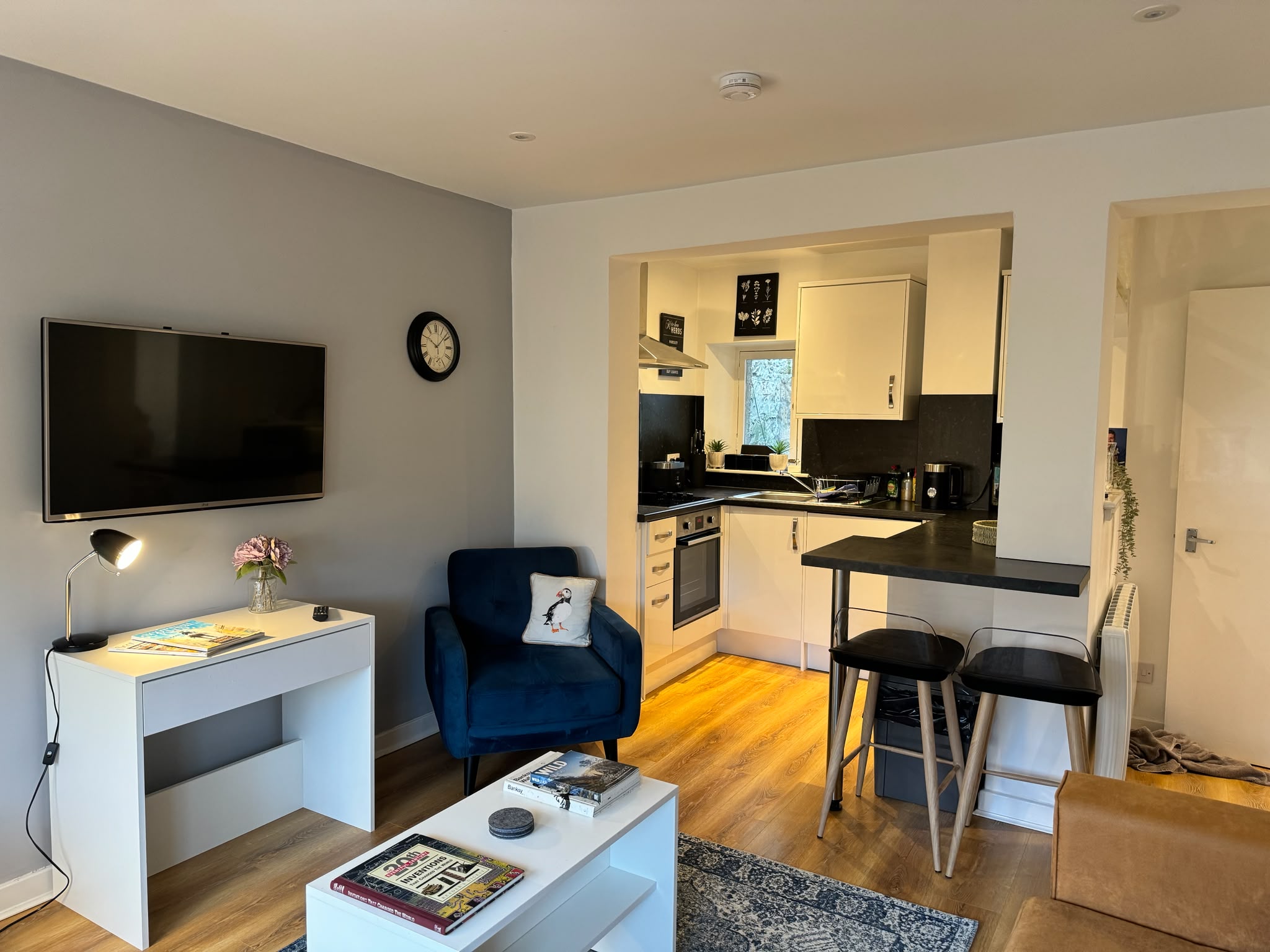 the living room from anothe angle showing the entrance to the kitchen and the tv