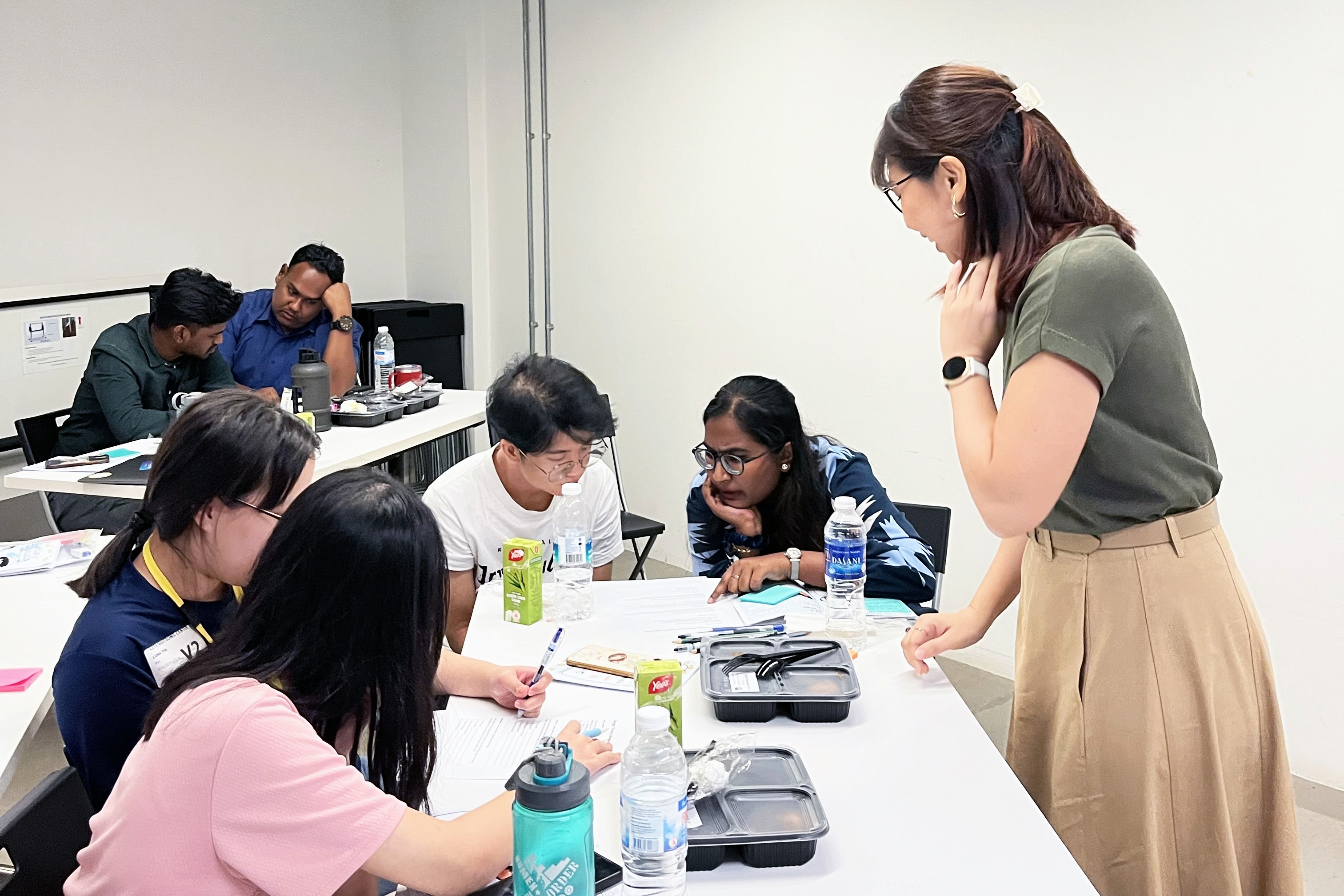 Workshop participants and the facilitator engaged in a discussion during the Designing a Problem Statement session